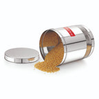 The container tilted on its side with the lid detached, pouring mustard seeds out onto the surface.
