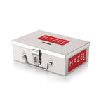 A closed stainless steel cash box with front clasp lock and red HAZEL branding, shown on a plain white background.