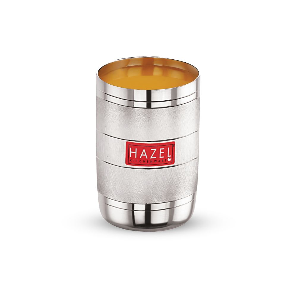 Steel glass filled with orange juice, front view on a plain white background.