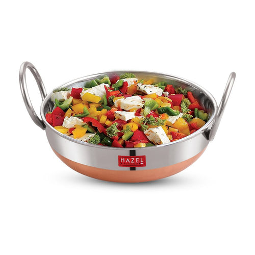 Copper-base kadai filled with a colorful vegetable and paneer salad, shown on a plain white background.