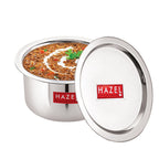 Tope with lid ajar revealing a garnished curry inside, matching lid resting beside it on a white background.