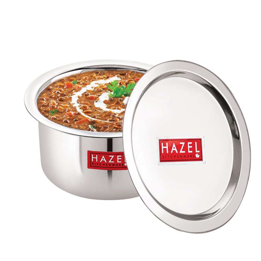 Tope with lid ajar revealing a garnished curry inside, matching lid resting beside it on a white background.