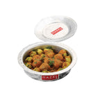 Bhagona filled with potato curry with its lid tilted beside it, shown on a plain white background.