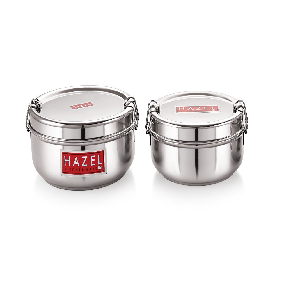 Two closed stainless steel tiffin boxes with locking clips side by side on white.
