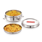 Open steel tiffin box filled with yellow poha next to its lid on a white background.