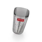 Angled three-quarter view of the dimpled-texture steel glass with red HAZEL label on a plain white background.