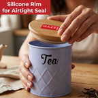 Hands lifting the wooden lid off the grey Tea canister on a wooden table with a red label reading Silicone Rim Airtight Seal.