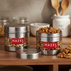 Stainless steel storage container with transparent section shown in a kitchen setting.