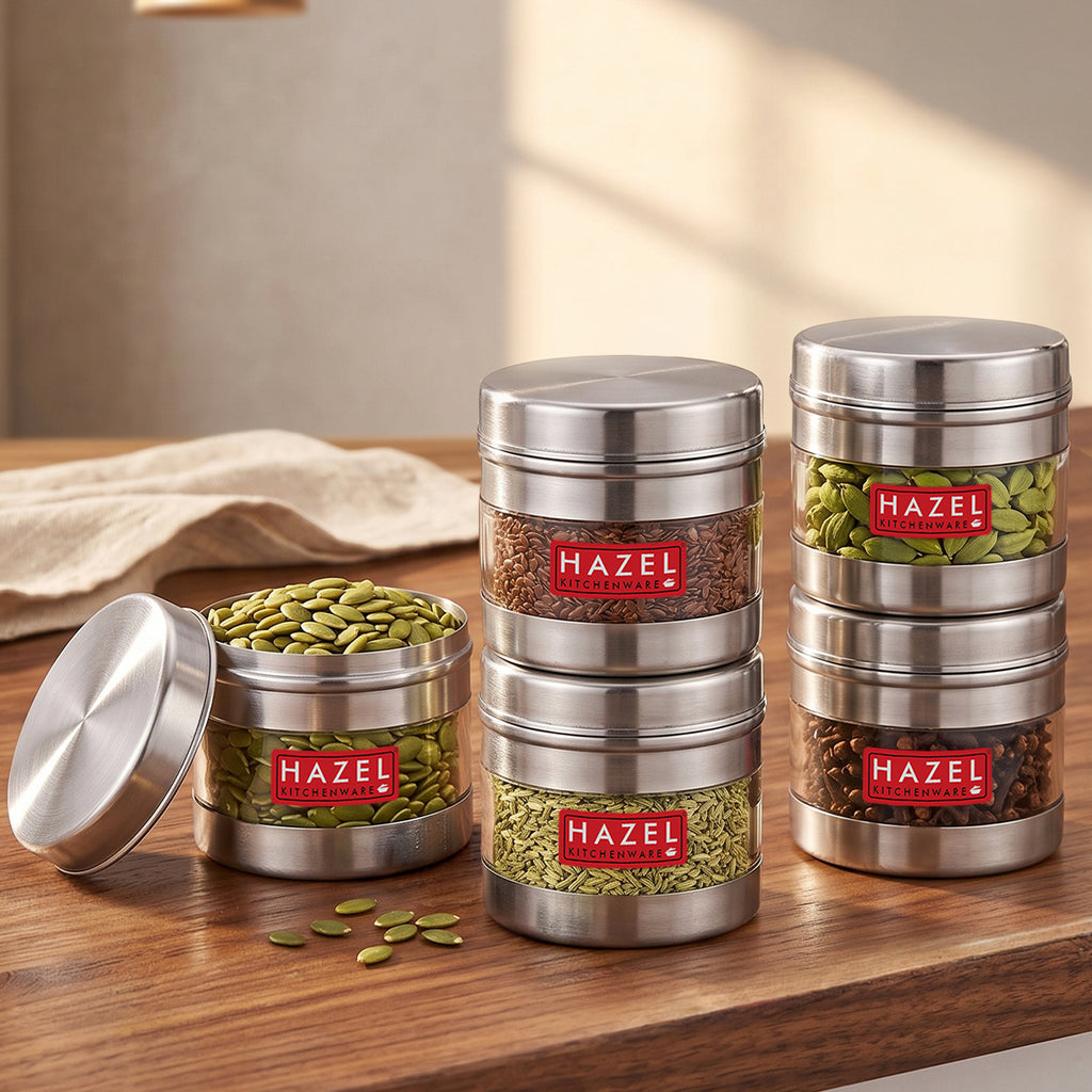 Five transparent steel containers arranged in two stacks beside one open container.