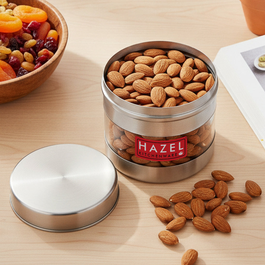 Stainless steel storage container with transparent section shown in a kitchen setting.